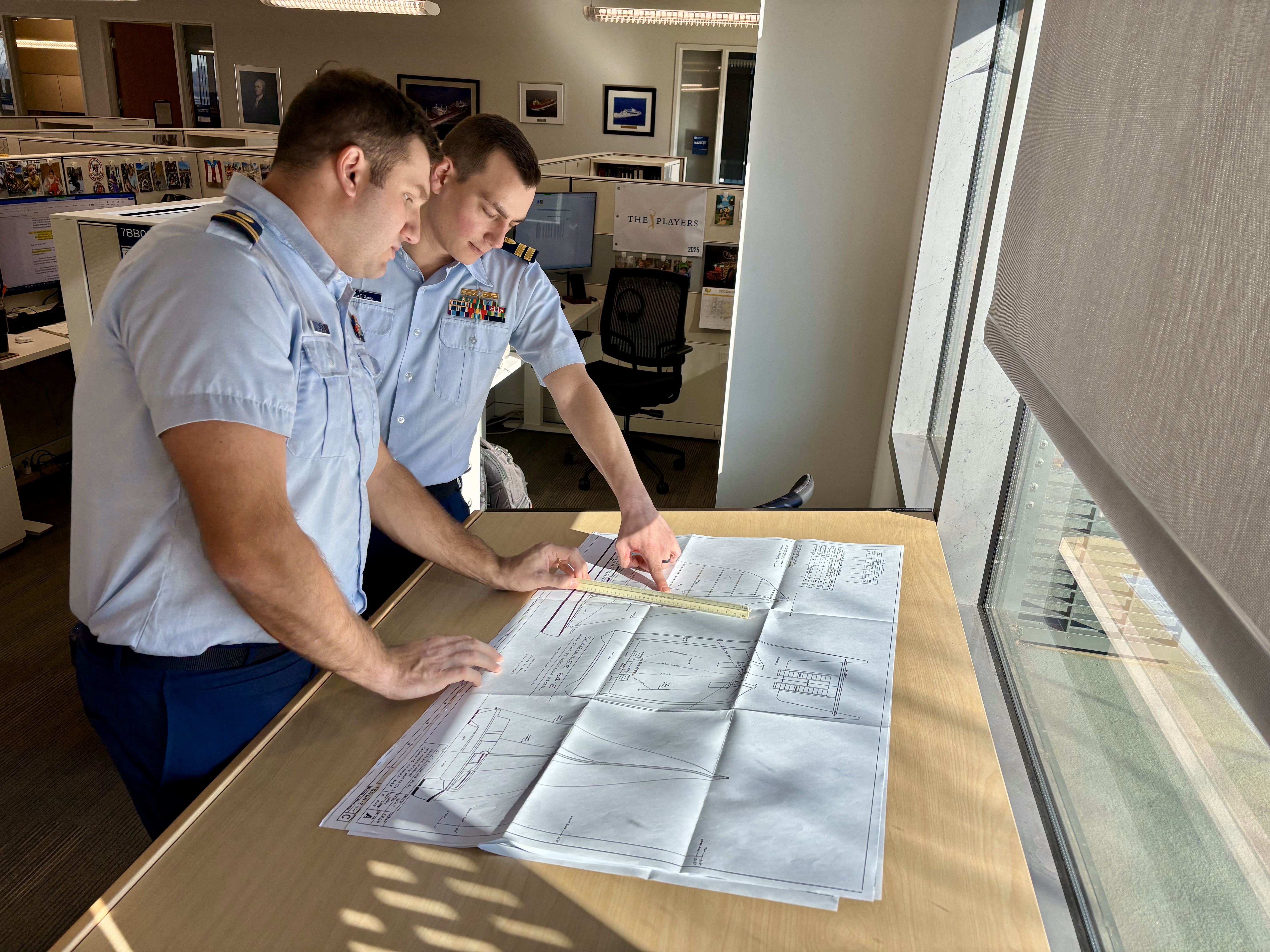 Staff engineers review a sailing vessel plan